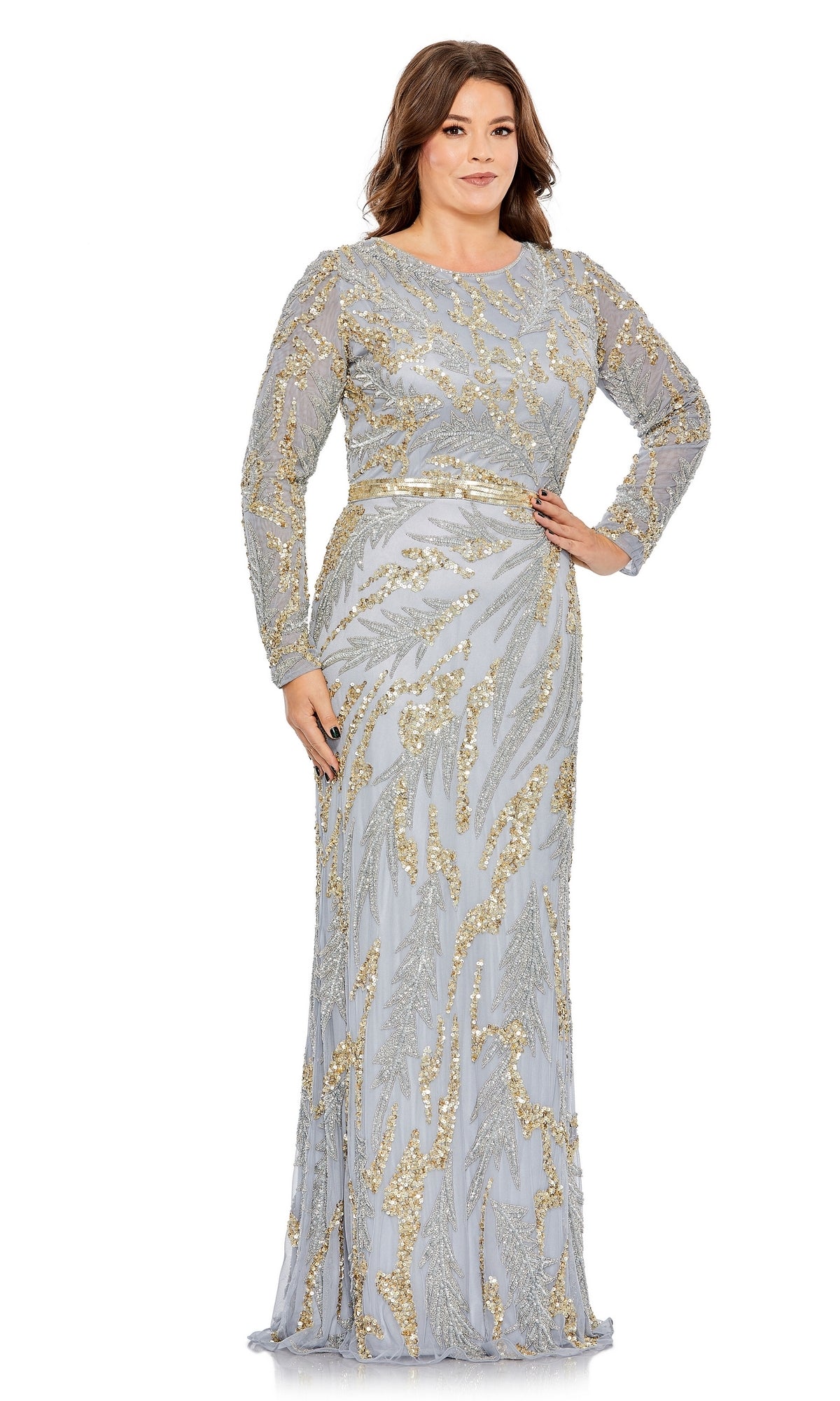 A woman poses confidently with one hand on her hip, modeling the Long Plus-Size Formal Dress 5358 by Mac Duggal in shimmering silver and gold against a plain white background.